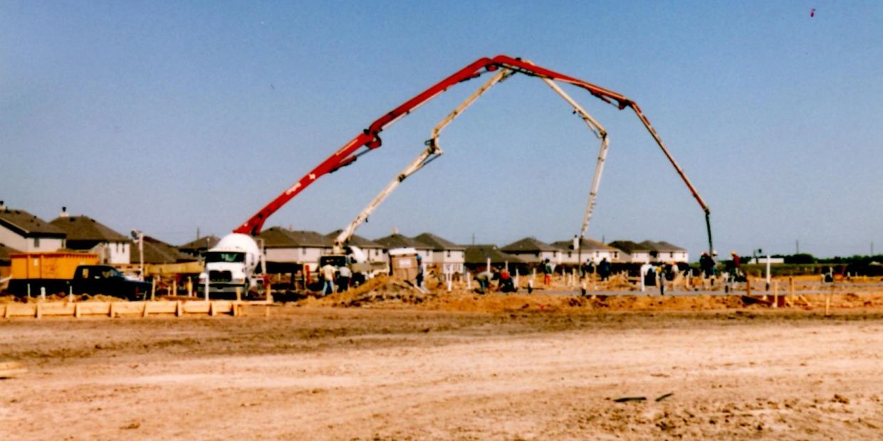 Construction site with concrete pumps and workers.