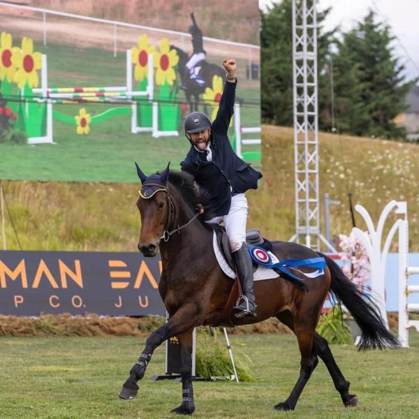 Equestrian rider celebrating victory on a horse.