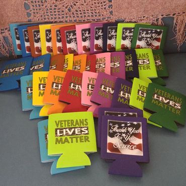 Colorful koozies with veterans' appreciation messages arranged on a table.