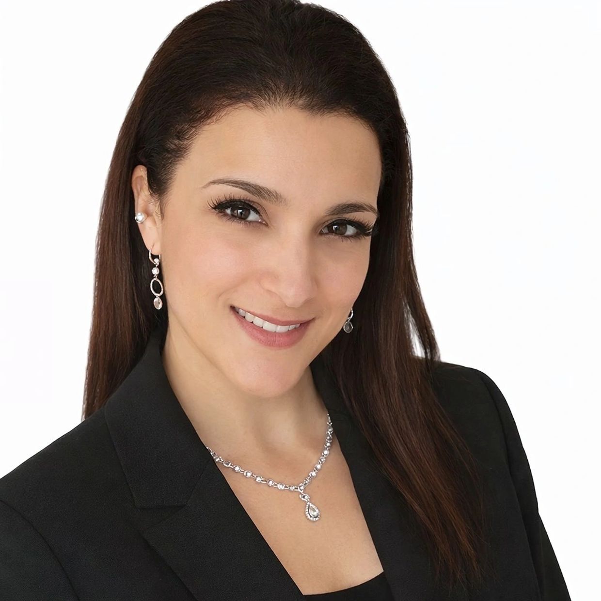 Woman with long dark hair wearing a black blazer and silver jewelry.