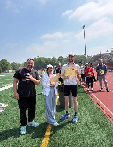 People celebrating a certificate on a sports field.