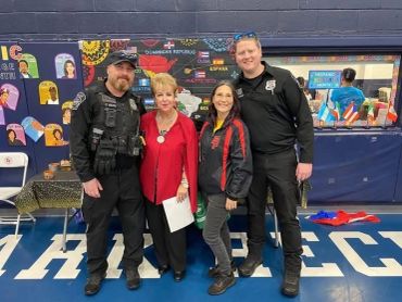 Two officers and two civilians posing in gym.