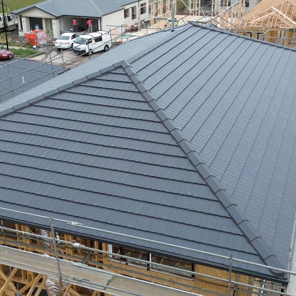 New residential houses under construction with scaffolding and tiled roofs.