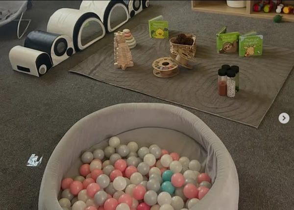 A cozy play area with a ball pit and educational toys on the floor.