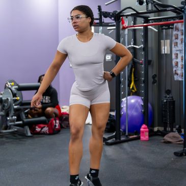 Woman in athletic outfit and high heels at the gym.