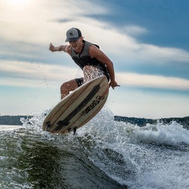 Surfer catching air above a wave on a cloudy day.