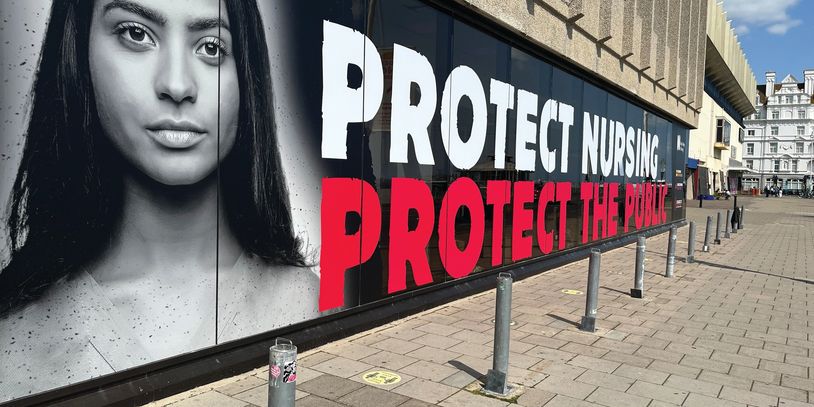Large mural advocating nursing and public protection on a city street.