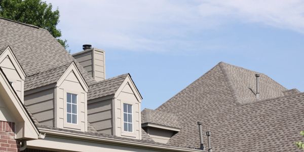 Close-up view of residential rooftops under a clear sky.