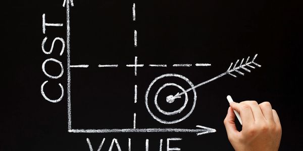 Chalkboard graph shows cost versus value with arrow hitting target.