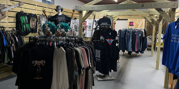 Clothing store with band t-shirts and casual wear on racks and hangers.