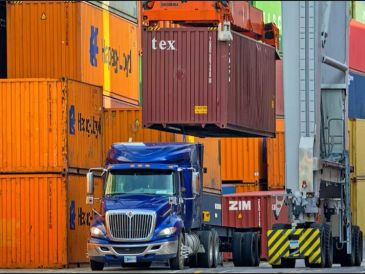 Truck loading containers at shipping yard.