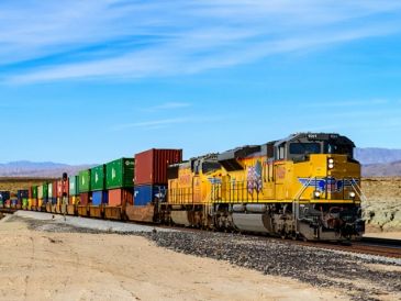 A freight train travels through a desert landscape.