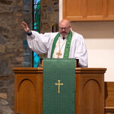 Priest delivering a sermon at the pulpit.
