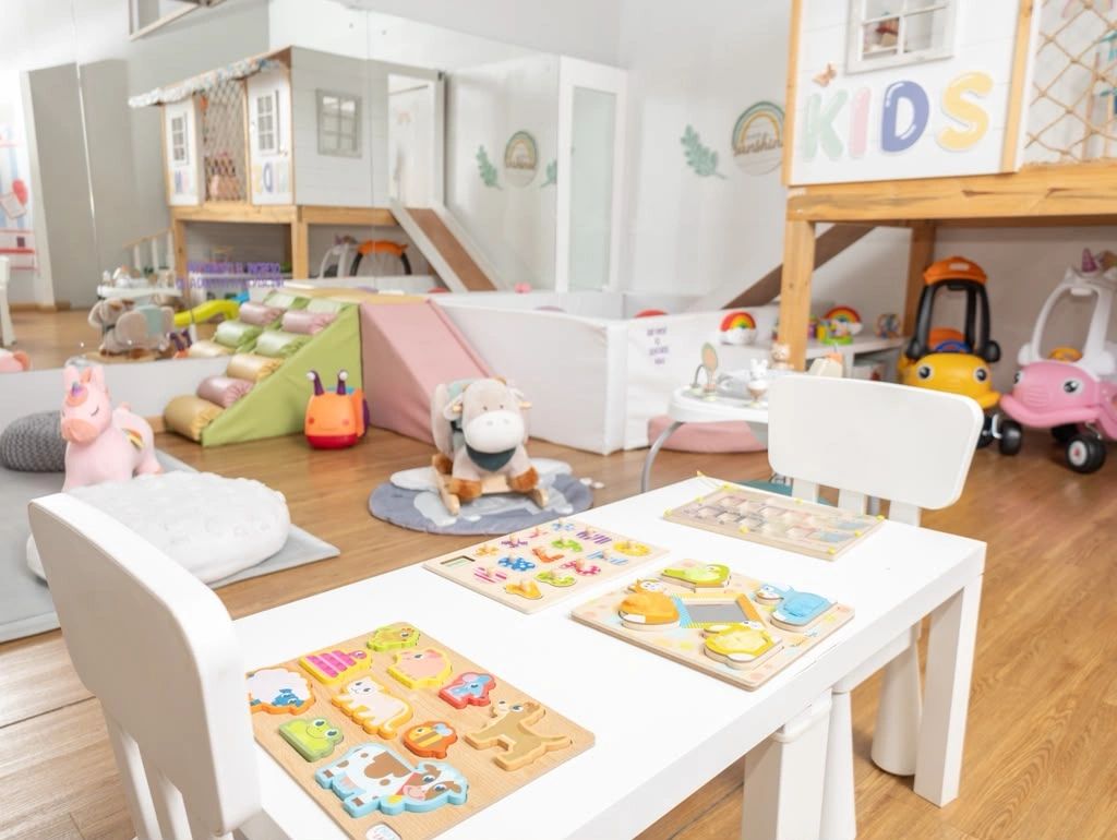 Sala de juegos para niños con juguetes y mesas.