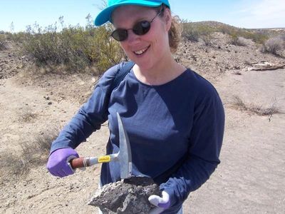 Michele Buckler holding a rock with a pick hammer. 