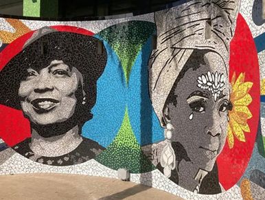 Mural of two women with vibrant backgrounds.