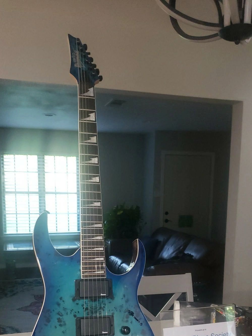 Blue electric guitar with sharp design in a living room setting.
