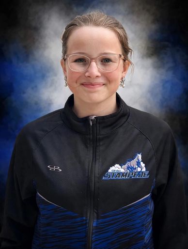 Smiling young woman in a sports jacket with glasses.
