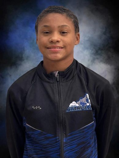 Young athlete in a team jacket smiling.