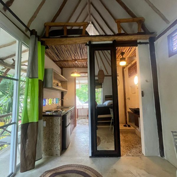 Cozy rustic cabin interior with loft, kitchen, and bedroom.