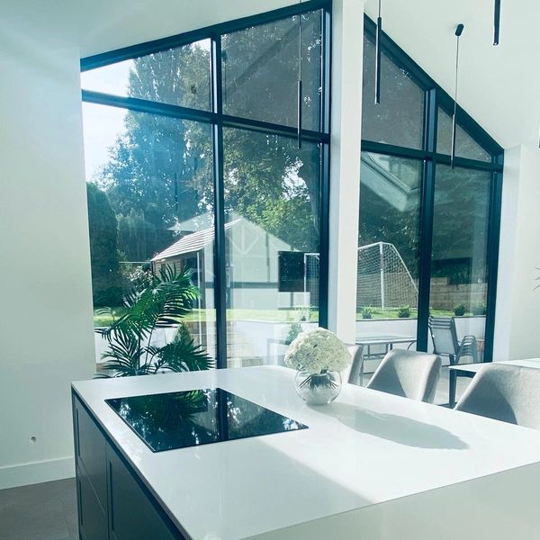 Modern kitchen island with a sleek cooktop and fresh flowers.