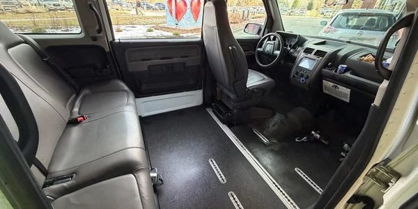 Spacious vehicle interior with leather seats and empty floor space.