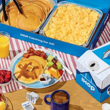 IHOP catering with pancakes, scrambled eggs, bacon, fruit, coffee, and orange juice.