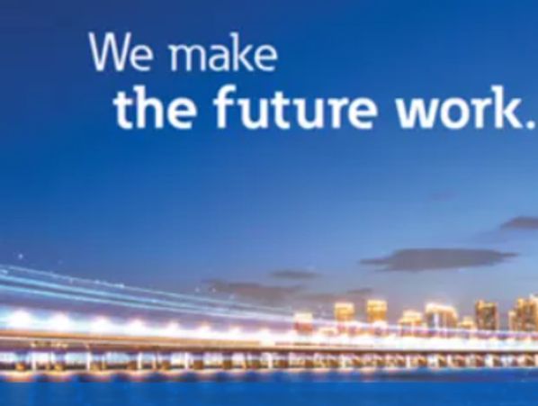Cityscape with illuminated bridge and future-oriented slogan.
