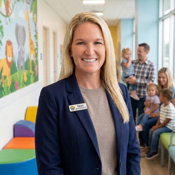 A smiling woman named Taryn, a speech therapist, in a colorful children's clinic.