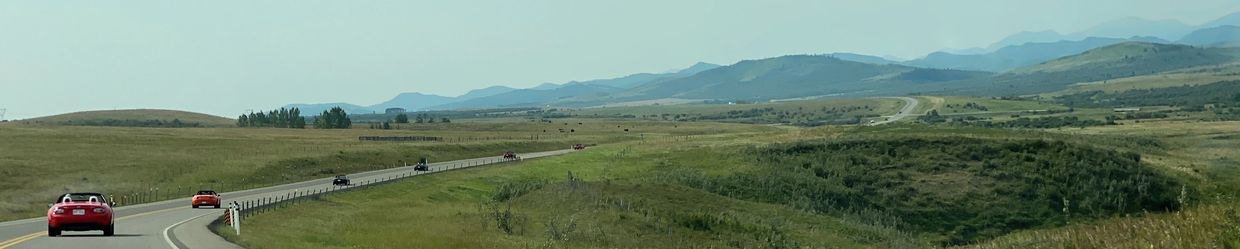 Group of Miata / MX-5 cars driving towards smokey mountains