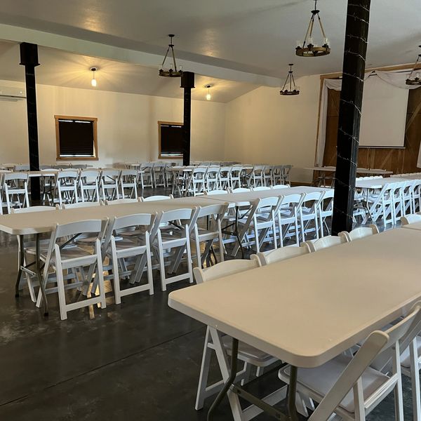 Empty event space with tables and chairs.