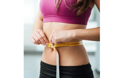 Woman measuring weight loss with measuring tape