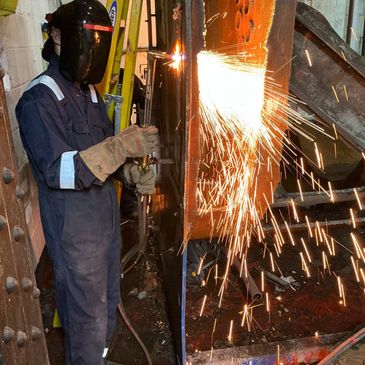 Person welding metal, sparks flying.