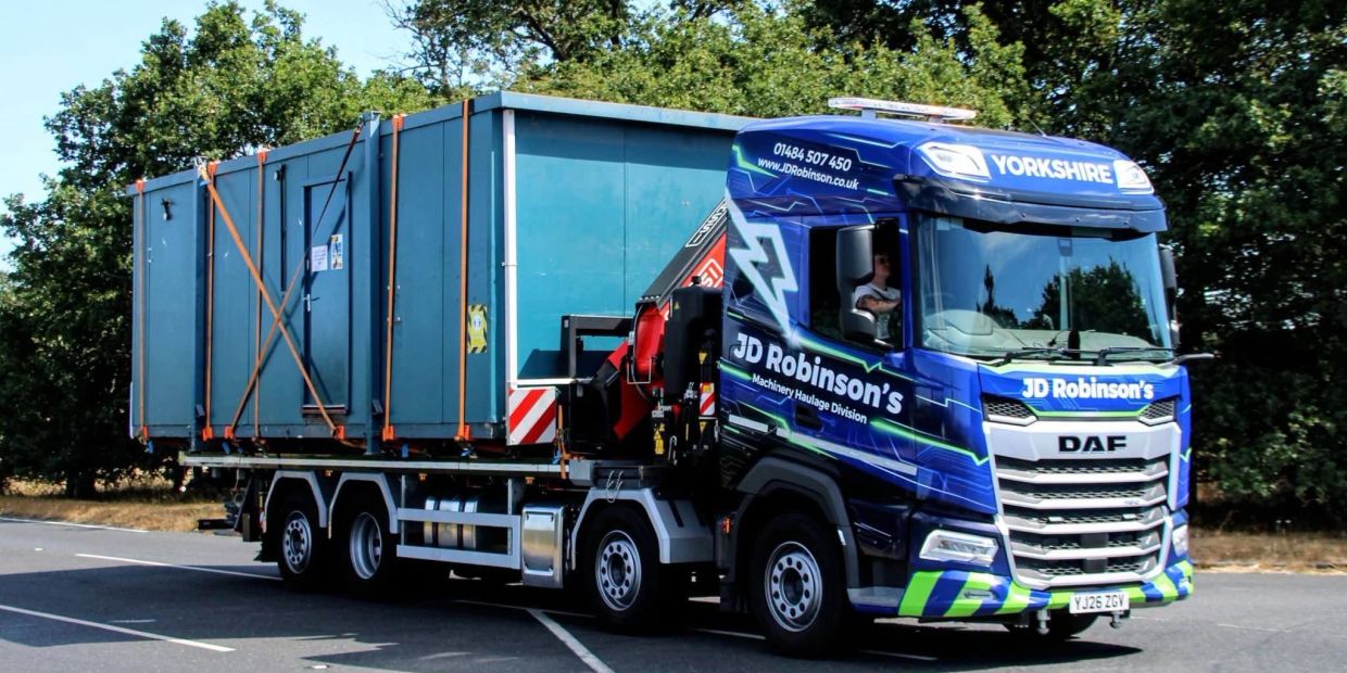 Blue JD Robinson's haulage truck on a road.