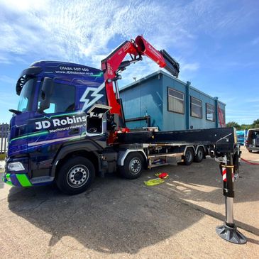 Truck with crane lifting a container unit.