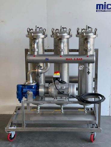 Industrial filtration system with three stainless steel filter housings on a wheeled frame.