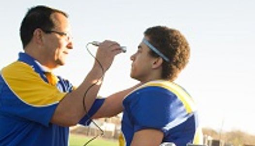 Coach checking football player's temperature.