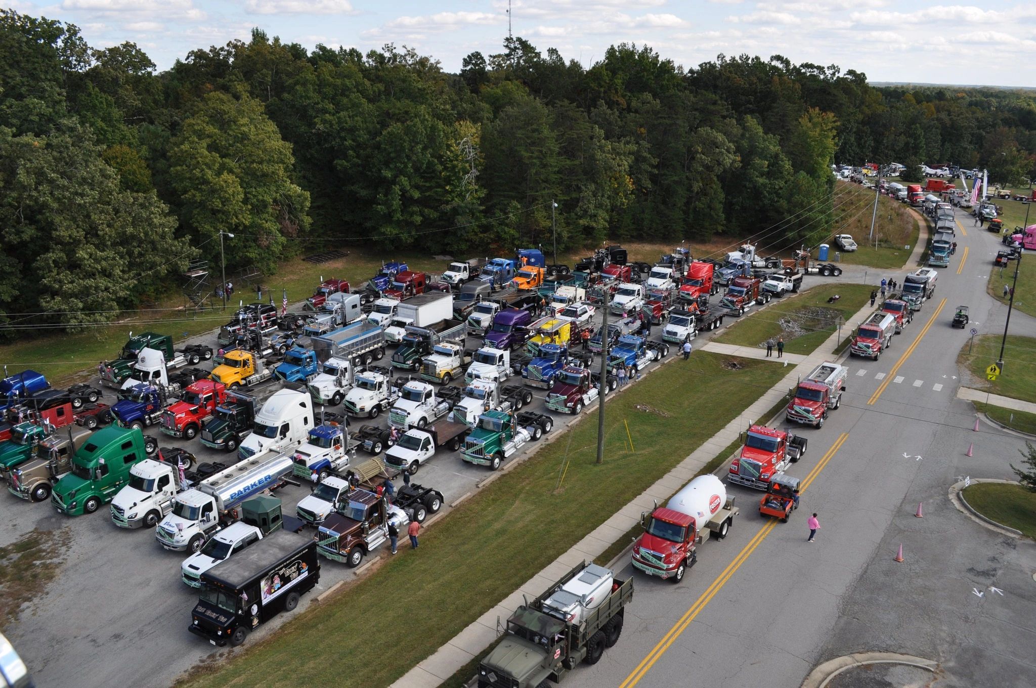Large gathering of colorful trucks in a parking area.