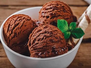 Three scoops of chocolate ice cream in a bowl.