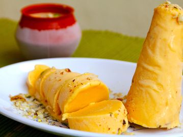 Traditional Indian sweet dessert served on a white plate with a container in the background.
