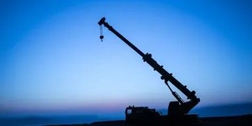 Silhouette of a crane against a twilight sky.