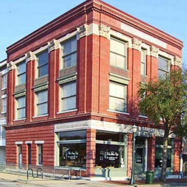 Historic red brick corner building with large windows and decorative details.