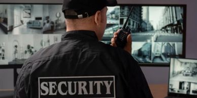 Security guard monitoring surveillance cameras.