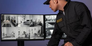 Security guard monitoring surveillance screens.
