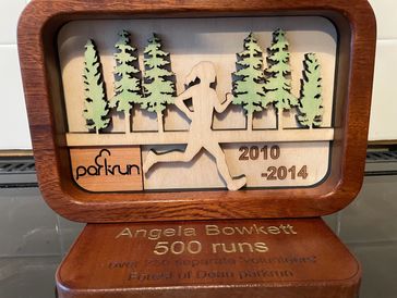 Wooden parkrun award for Angela Bowkett's 500 runs from 2010 to 2014.