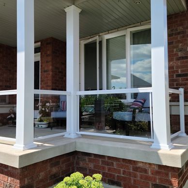 framed glass railings and white aluminum columns on concrete porch