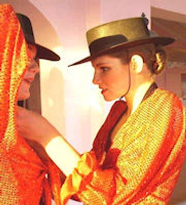 Two people dressed in orange outfits and hats.