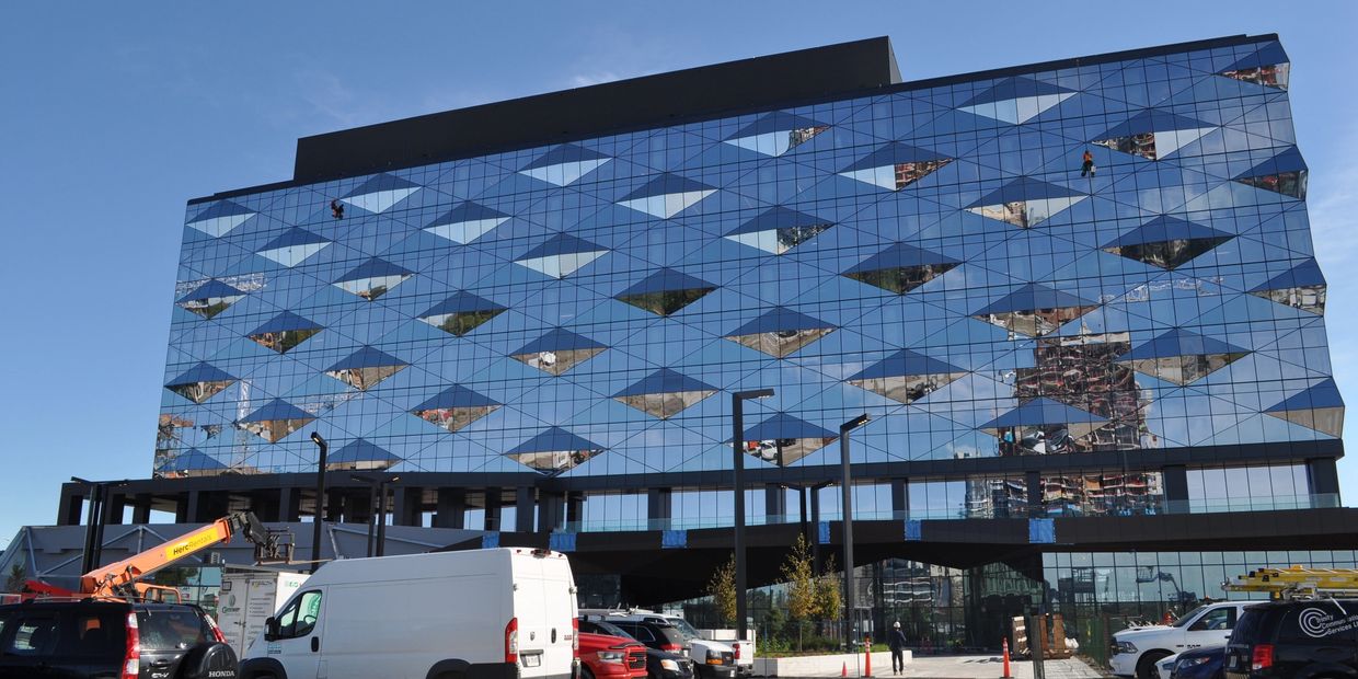 Modern geometric glass building with reflective windows.