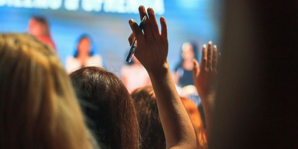 Person raising hand in audience