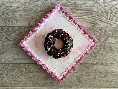 White cake with Chocolate frosting on a pink square canvas